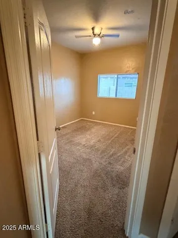 an empty room with closet and mirror
