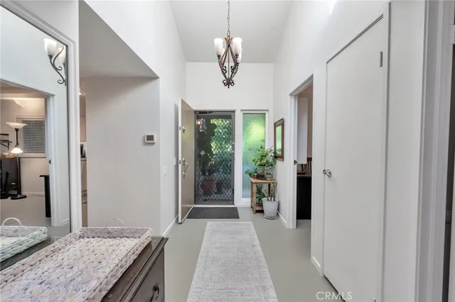a view of a hallway with wooden floor and a kitchen