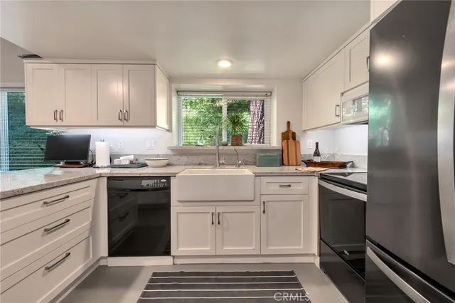 a kitchen with a sink a refrigerator and chairs