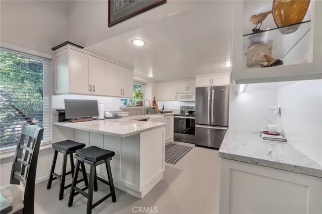 a kitchen with stainless steel appliances granite countertop a sink refrigerator and microwave