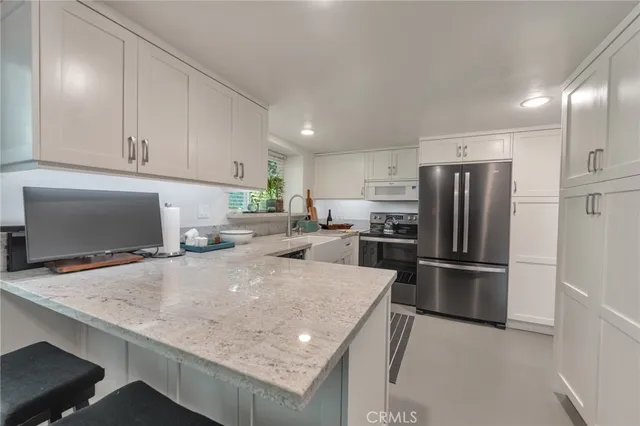 a kitchen with stainless steel appliances a refrigerator and a stove top oven