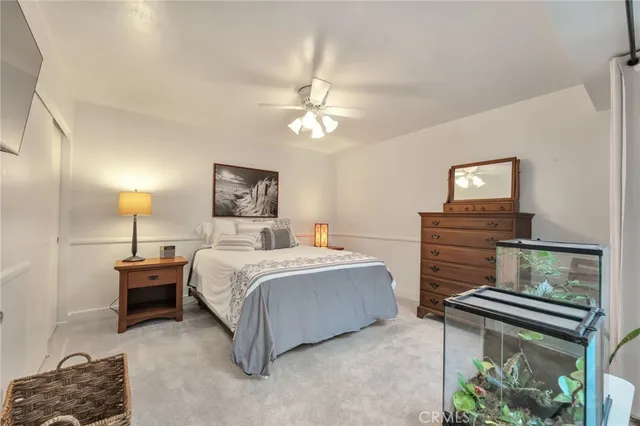 a spacious bedroom with a large bed and a chandelier