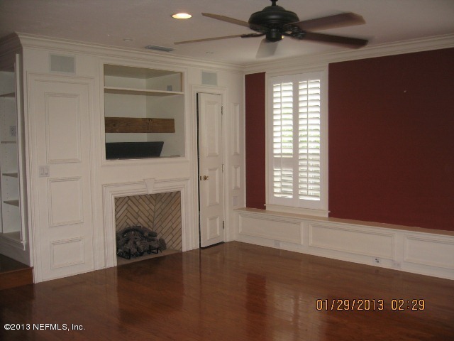 11860 Mandarin Road Jacksonville, FL 32223 - Photo 13 of 43 a view of an empty room with wooden floor fireplace and a window