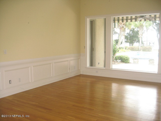 11860 Mandarin Road Jacksonville, FL 32223 - Photo 5 of 43 a view of an empty room with wooden floor and a window