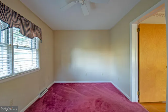 a view of a hallway with wooden floor and windows
