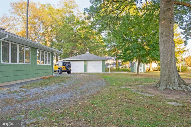 a view of a house with backyard and tree