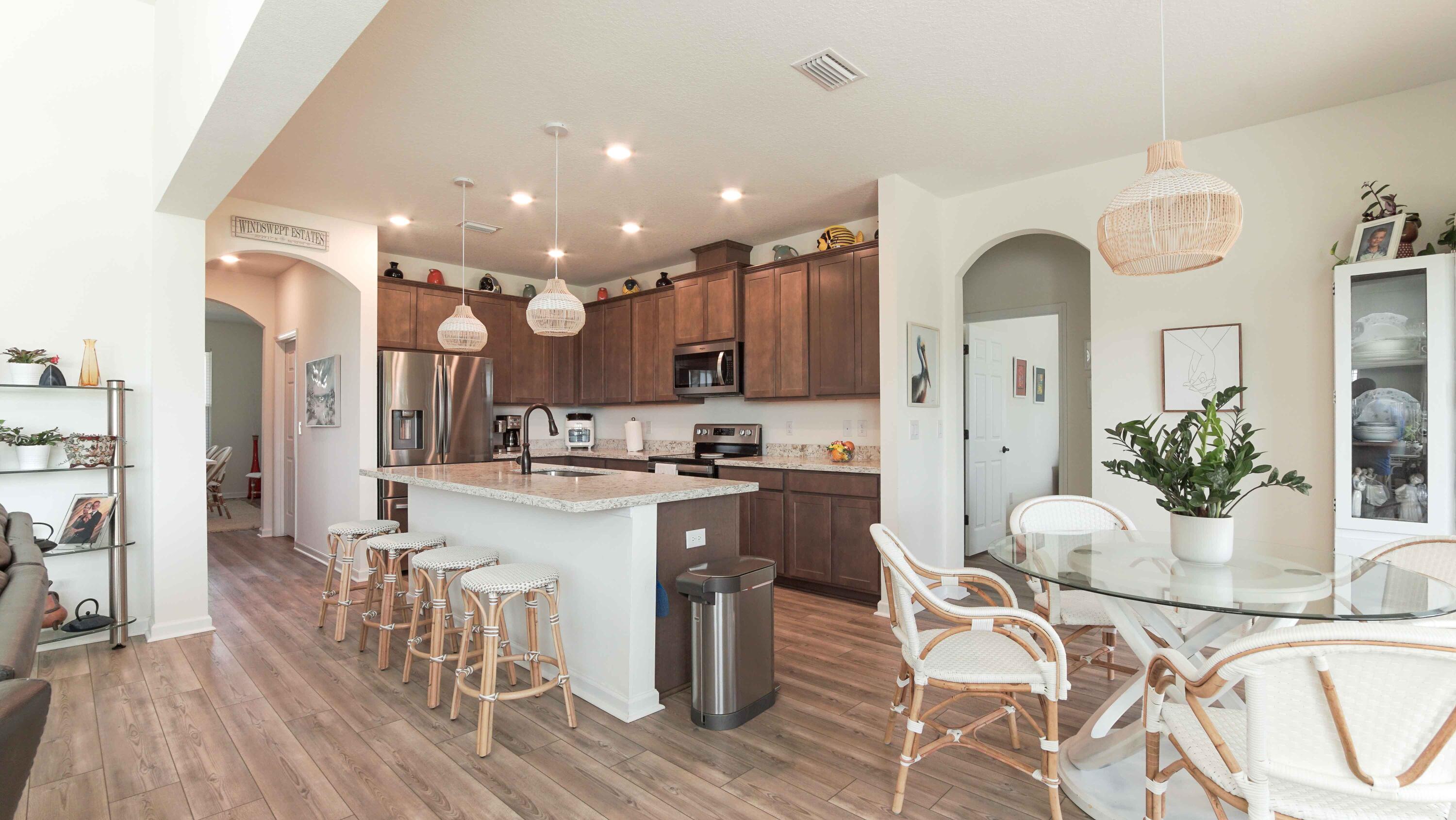 322 Fairway Crossing Freeport, FL 32439 - Photo 3 of 56 a kitchen with stainless steel appliances kitchen island granite countertop a stove a refrigerator a kitchen island with a dining table and chairs