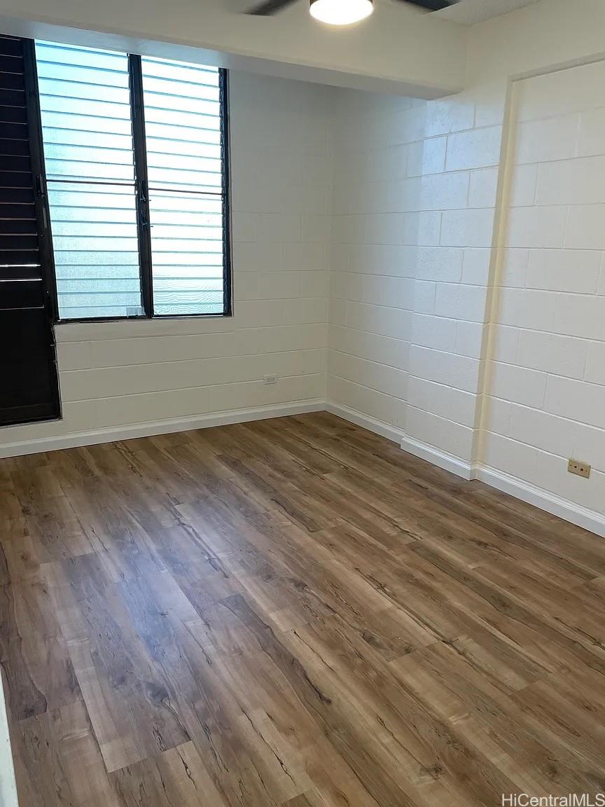 1906 Fern Street, Unit 304 Honolulu, HI 96826 - Photo 5 of 6 an empty room with wooden floor and windows