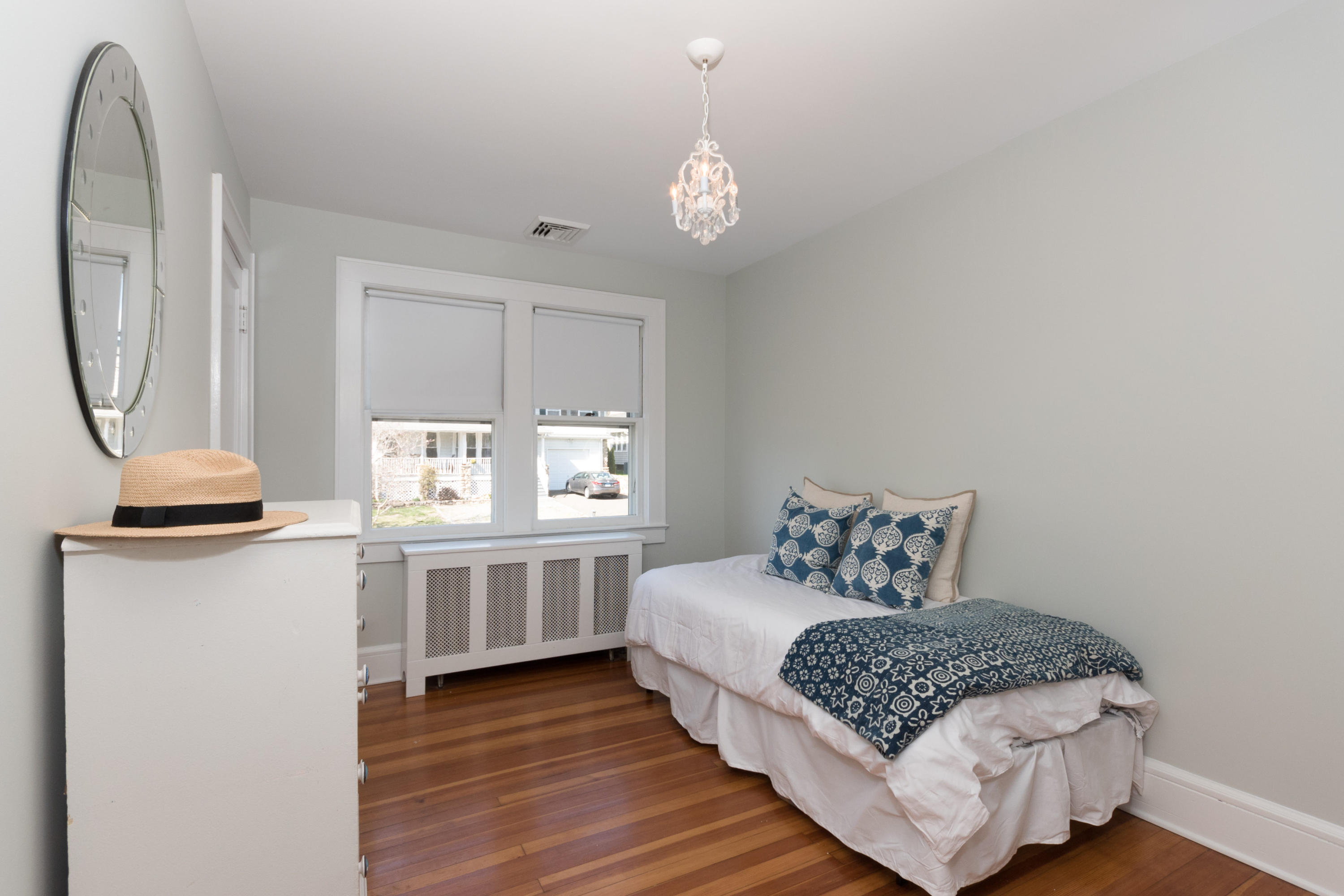 12 Maple Street Darien, CT 06820 - Photo 22 of 42 a bedroom with a bed and a chandelier
