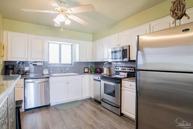 a kitchen with stainless steel appliances granite countertop a stove a sink and a refrigerator