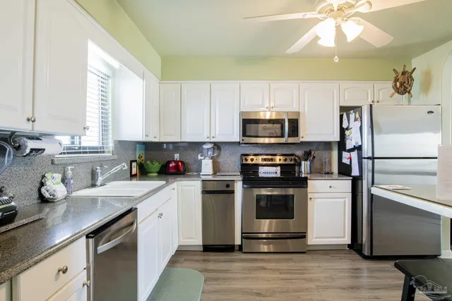 a kitchen with a sink a microwave a refrigerator and cabinets