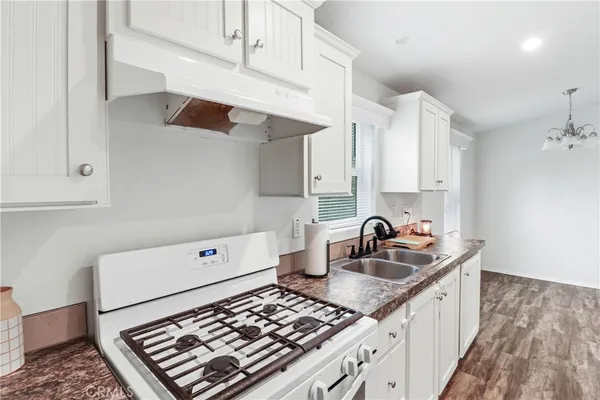 a kitchen with kitchen island a sink stove top oven and cabinets