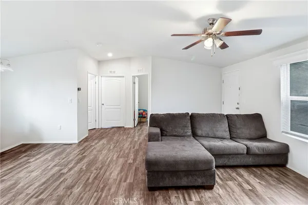 a living room with furniture and a ceiling fan