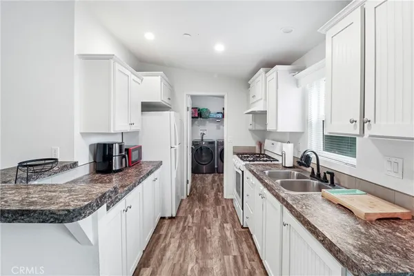 a kitchen with granite countertop a sink stove and cabinets