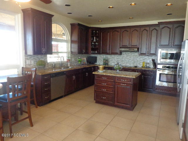 274 Camino Panama Rio Rico, AZ 85648 - Photo 7 of 23 a kitchen with stainless steel appliances granite countertop a stove sink and cabinets