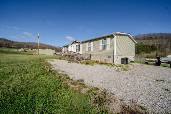 a view of a house with a yard and a view of a house