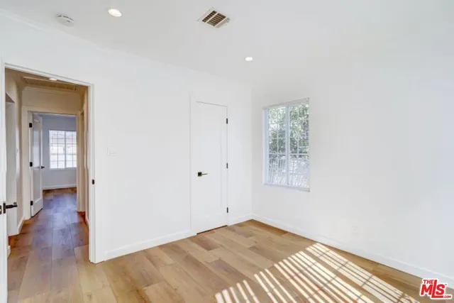 a view of a big room with wooden floor and windows