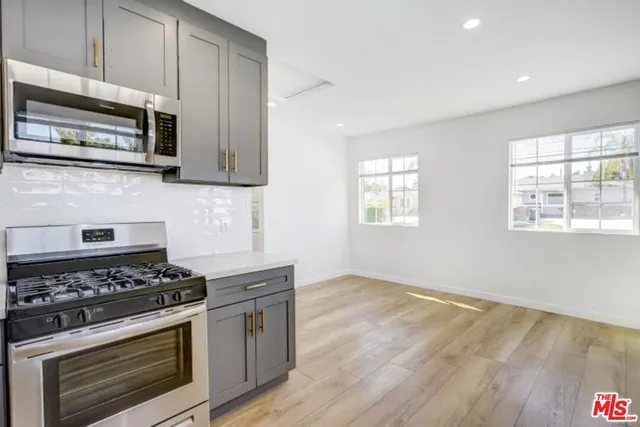 a kitchen with granite countertop cabinets stainless steel appliances and wooden floor