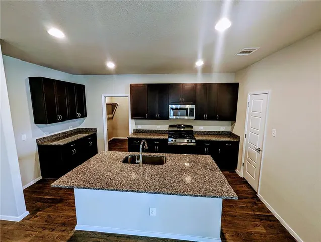 a kitchen with stainless steel appliances wooden cabinets and granite counter tops