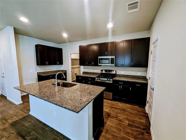 a kitchen with stainless steel appliances granite countertop a sink and a microwave