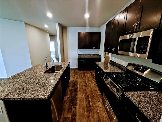 a kitchen with sink stove and cabinets