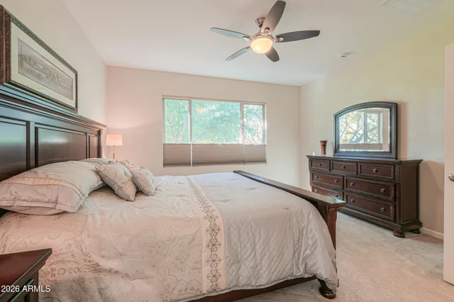 a bedroom with a bed and a ceiling fan