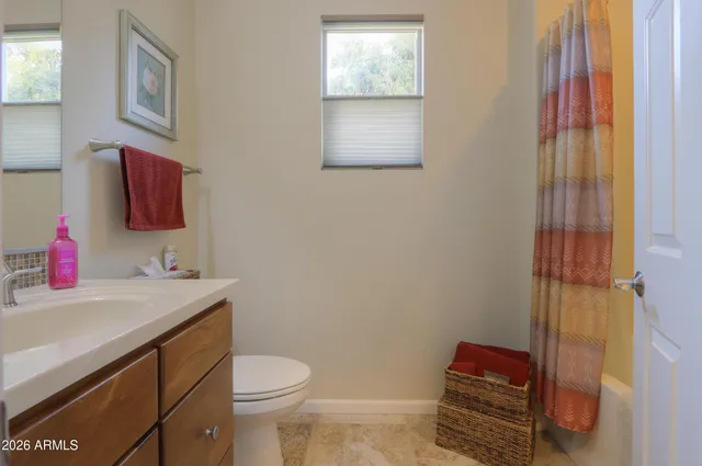 a bathroom with a toilet sink vanity and mirror