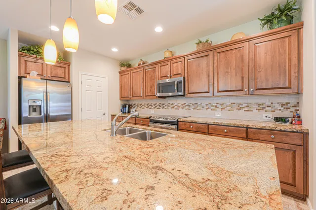 a large kitchen with kitchen island granite countertop wooden cabinets and a granite counter tops