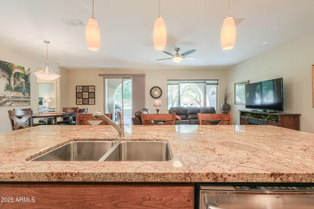 a kitchen with kitchen island granite countertop wooden cabinets and refrigerator