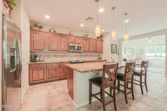 a large kitchen with kitchen island a stove a sink a refrigerator and a wooden cabinets