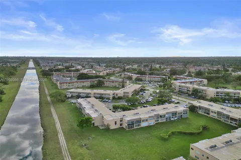 an aerial view of a house with a garden and lake view