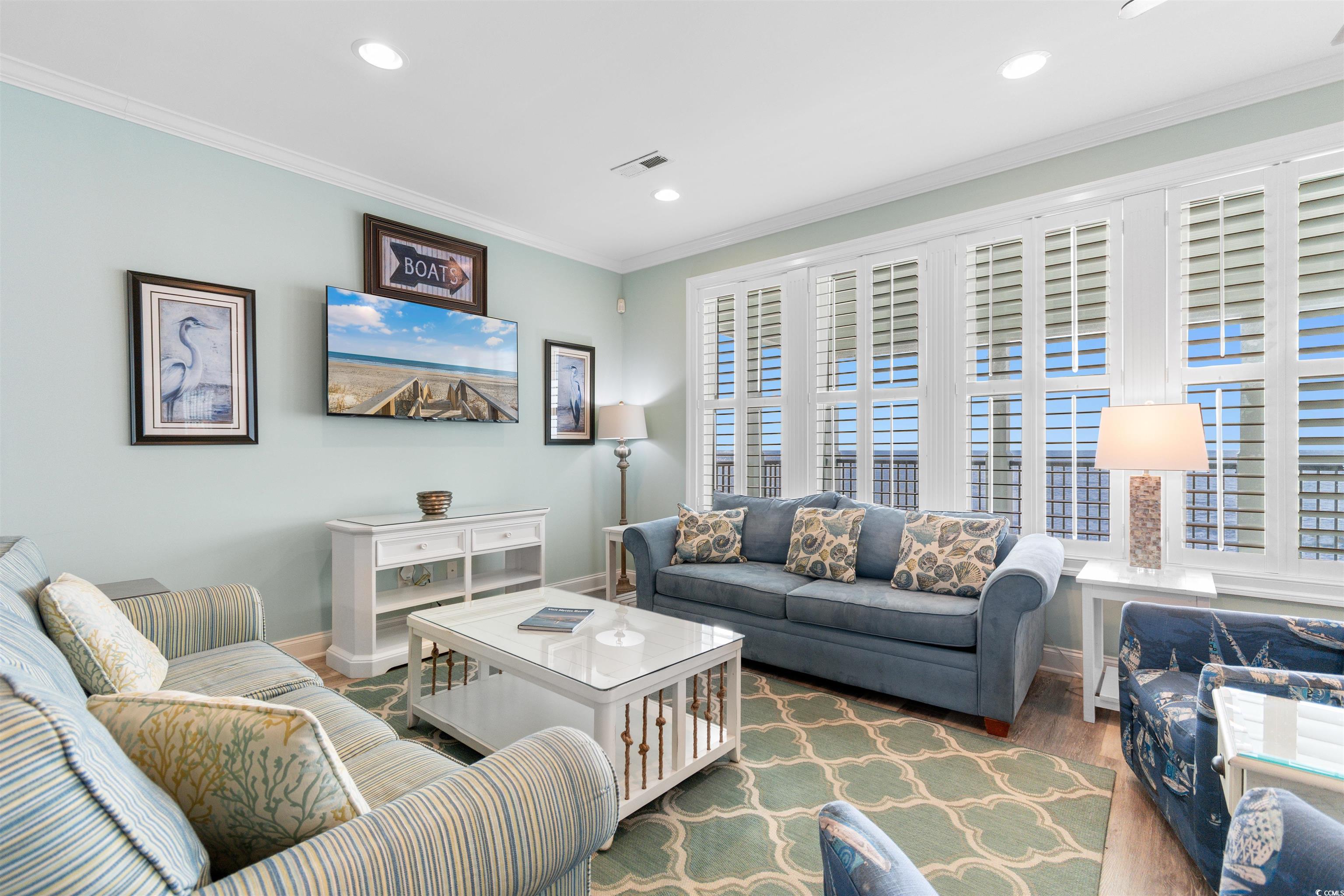 703 South Waccamaw Drive Murrells Inlet, SC 29576 - Photo 19 of 40 Oceanfront Living area with LVT floors, coastal decor, and plenty of natural light