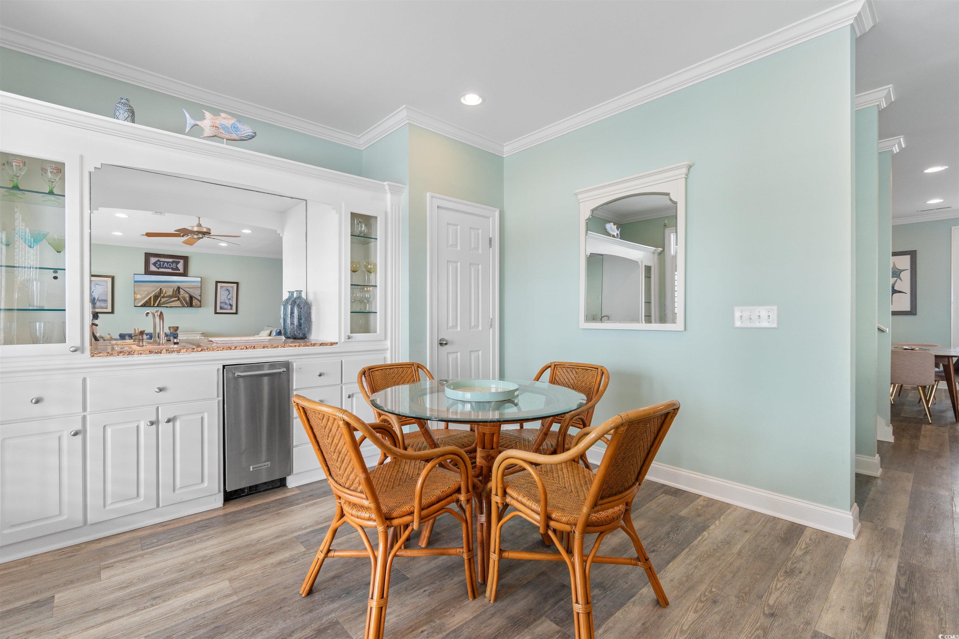 703 South Waccamaw Drive Murrells Inlet, SC 29576 - Photo 22 of 40 Dining space featuring bar with sink, light wood-style floors, crown molding