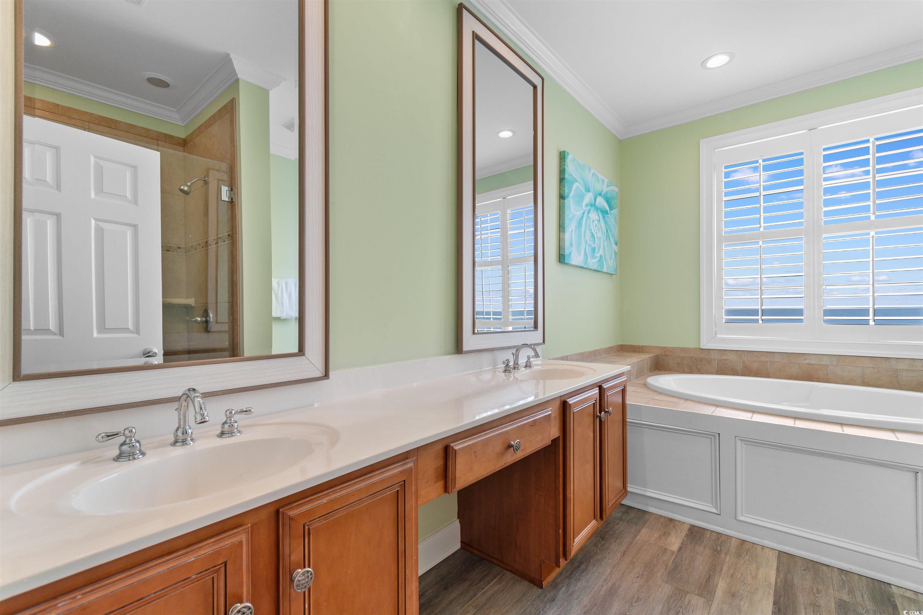 703 South Waccamaw Drive Murrells Inlet, SC 29576 - Photo 34 of 40 Oceanfront En Suite Bathroom with crown molding, double vanity, wood finished floors, a jetted garden tub, and a tile hower