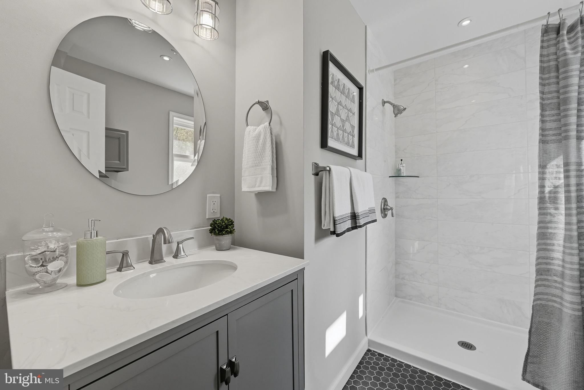 5209 Cedar Road Alexandria, VA 22309 - Photo 22 of 42 a bathroom with a sink a mirror a vanity and shower