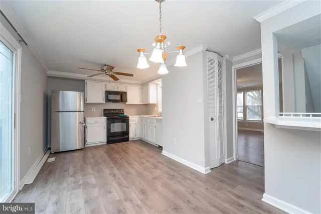 a view of a kitchen with refrigerator and wooden floor