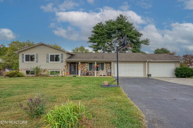 a front view of a house with a yard and trees