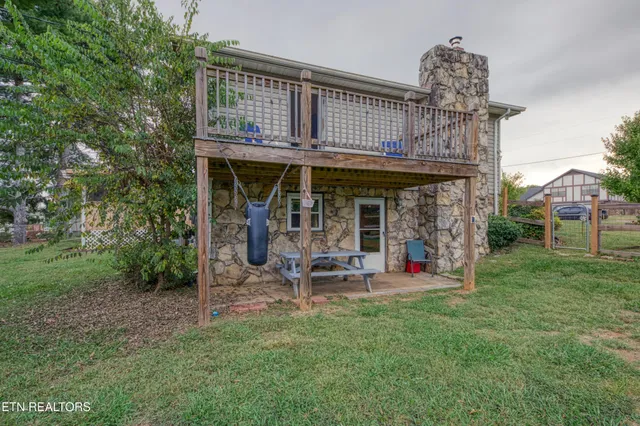 a view of a chair and table in backyard of the house