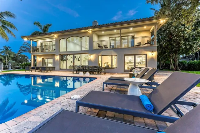 a view of a patio with couches table and chairs with wooden floor and fence