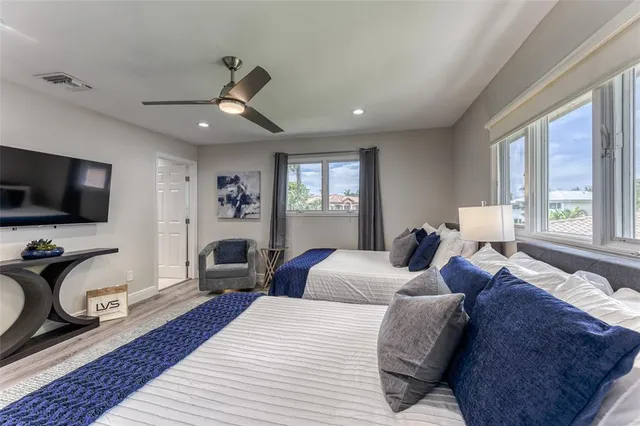 a bedroom with a large bed and a flat tv screen