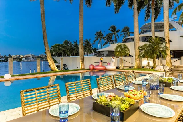 a dining room with furniture a large window and a chandelier
