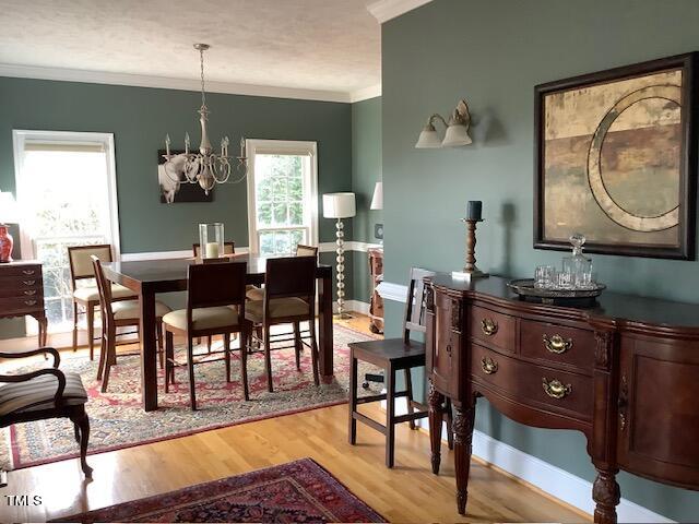 2125 Keith Hills Road Lillington, NC 27546 - Photo 26 of 66 a dining room with wooden floor a chandelier a wooden table and chairs