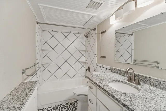 a bathroom with a granite countertop sink toilet and a mirror