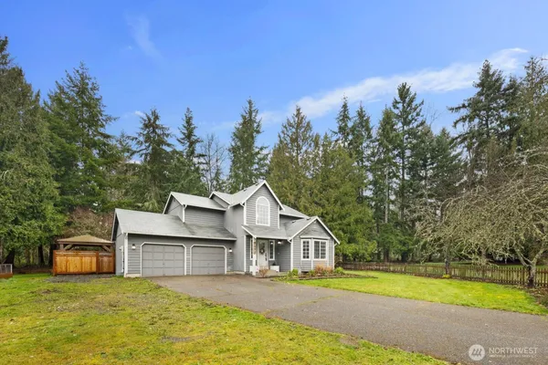 a view of a house with a big yard and large trees