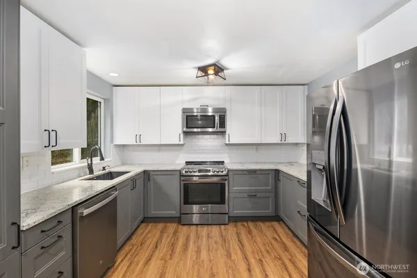 a kitchen with stainless steel appliances a sink stove and refrigerator