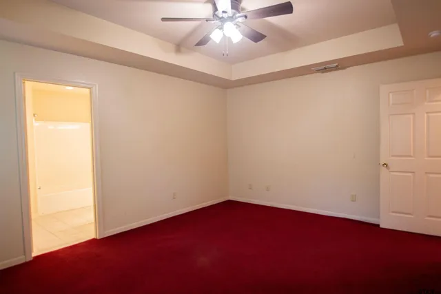 an empty room with a ceiling fan and wooden floor