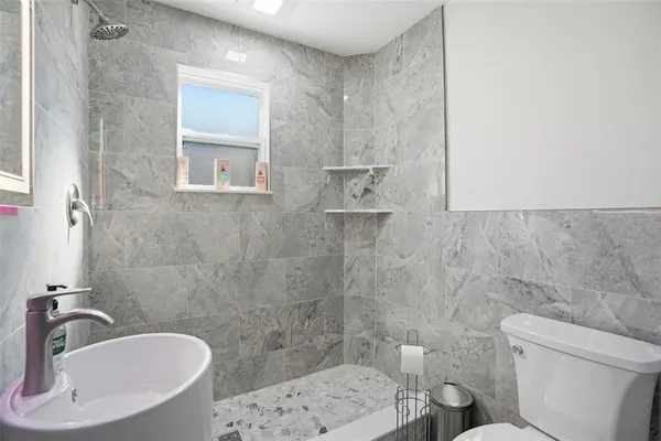 a bathroom with a sink toilet and shower