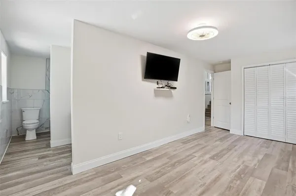 a view of a livingroom with wooden floor and a flat screen tv