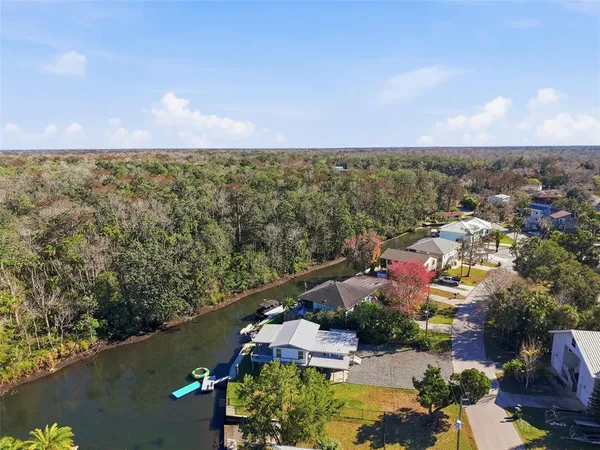 an aerial view of residential houses with outdoor space and lake view