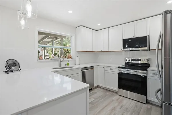 a kitchen with a stove a sink and a microwave